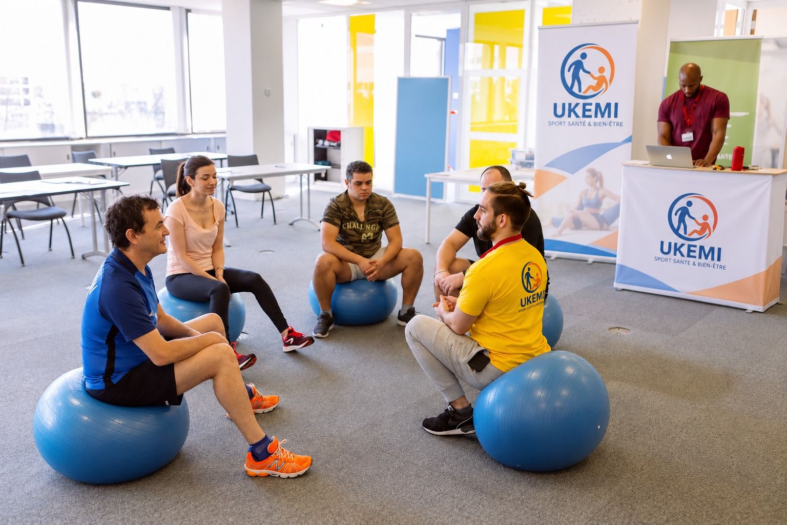Atelier UKEMI en entreprise : des salariés assis en cercle sur des ballons d'équilibre, avec un intervenant.